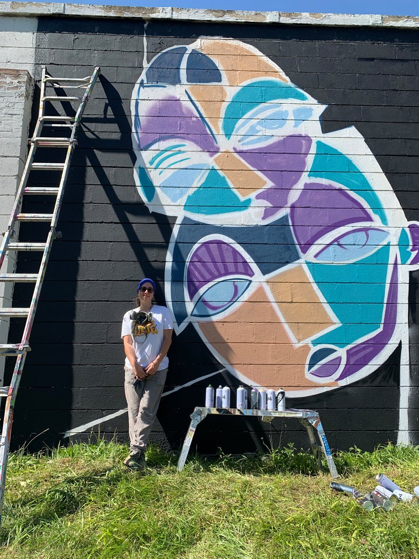 Artist Alice Mizrachi with her work in progress mural titled, "The Law of Attraction"