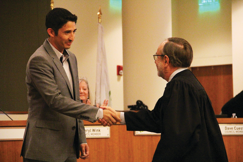 Englewood City Council member Othoniel Sierra, left, shakes hands with Englewood Associate Judge Vincent Atencio June 4 after being sworn into office by Atencio. The ceremony in the Englewood City Council chambers marked the end of a nearly five-month period in which the council operated one member short.