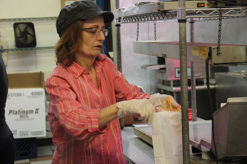 Dianne Zimmerman bags up a to-go order at Chicago Style Beef and Dogs. Zimmerman, owner of the Lakewood restaurant, said she feels like the pandemic has been going on for months. She added that the restaurant is working on finding the new norm.