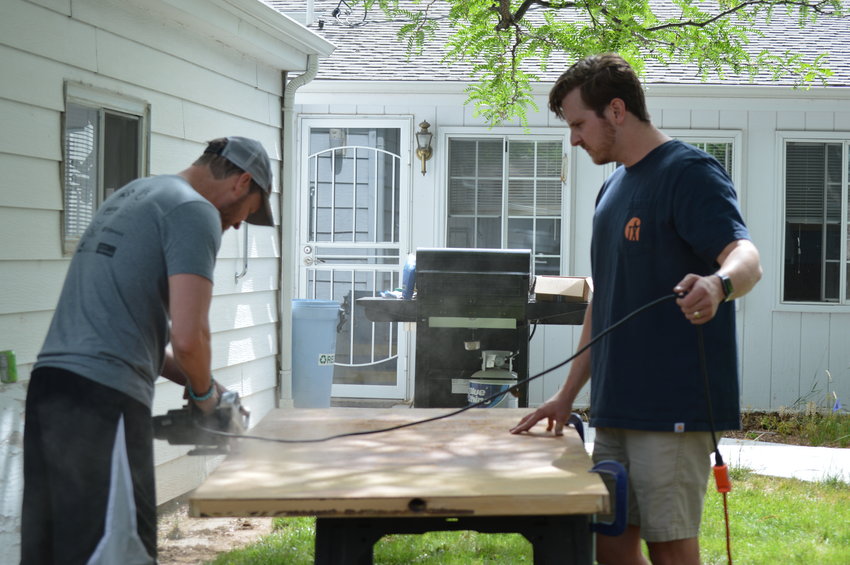 Shawn Lewis, Englewood's city manager, and Logan Dunning, a member of the Englewood Urban Renewal Authority, worked on preparing Kayleen Nichols' new door for her shed on June 18, 2022.
