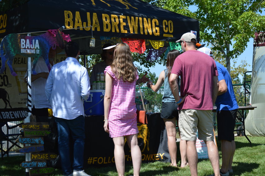 People waiting to get a beer sample as part of Centennial’s annual “Brew-N-Que” event on July 9, 2022, at Centennial Center Park.