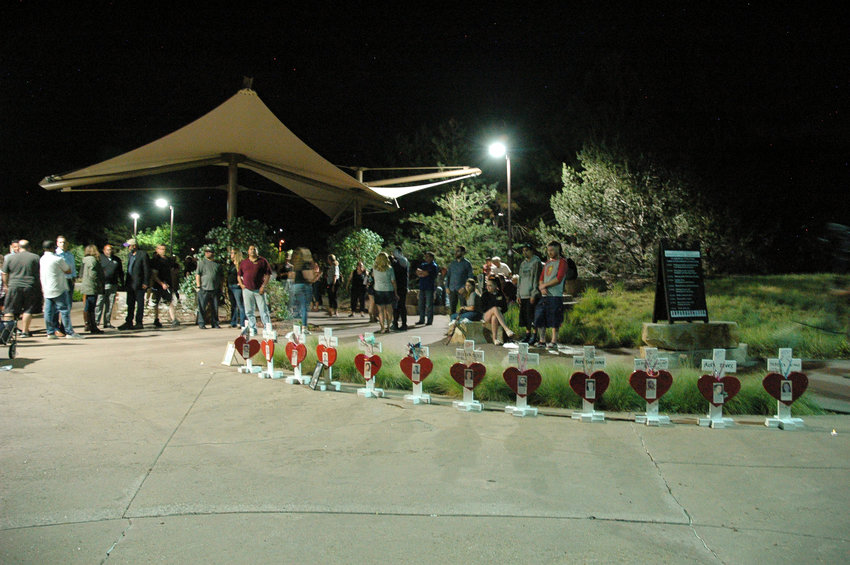 Before the midnight vigil officially began on July 20, 2022, many people gathered behind the 12 crosses that recognize those killed in the Aurora theater shooting 10 years ago.