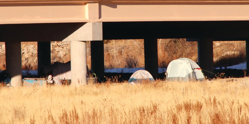 Tents and other materials sit at a homeless encampment in an open field March 1, 2022, near the Aurora-Centennial border.