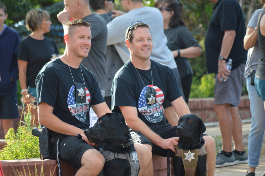 Deputy John Gray with therapy dog Rex, left, and Deputy Travis Jones with therapy dog Zeke, right, at the “RexRun for PAWSitivity” event, held Aug. 6 at Dove Valley Regional Park.