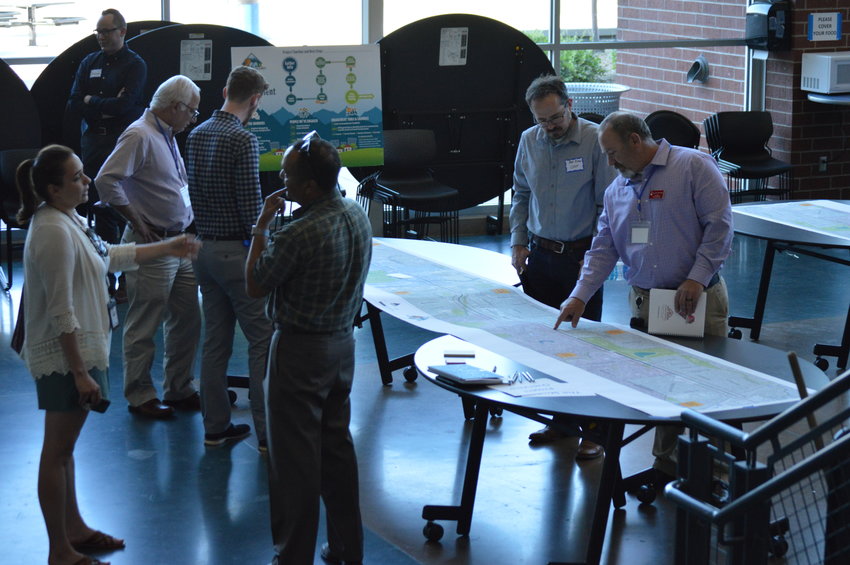 People at the Aug. 30 open house at Englewood High School discuss the 6.3-mile stretch of Hampden Avenue being studied.
