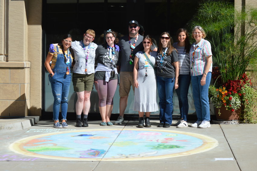 Employees from the Southglenn Library pose together on Sept. 24 at the Centennial Chalk Art Festival.