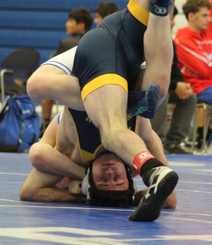Thanks to a series of moves by Grandview's Charlie Herting, in white, Frederick's Adrian Casillas does a head stand to avoid a pinfall combination during a 165-pound match at the Fort Lupton Bluedevil Invitational Dec. 3. Casillas escaped this hold, but Herting wound up winning the match in 1:42.