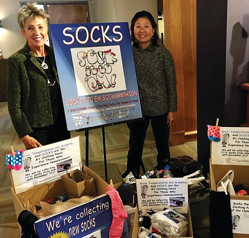 Sue Lee, left, and Phillis Shimamoto pose next to their Sock It To ‘Em sign in 2015.