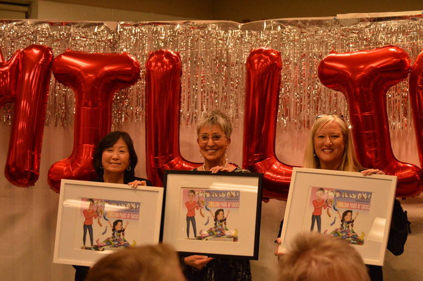 Phillis Shimamoto, Sue Lee and Tammie Limoges held up the artwork given to them by the board of directors during the Feb. 16 celebration.