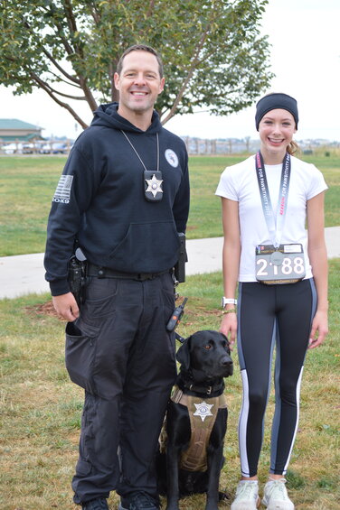 Deputy Travis Jones, a school resource officer at Newton Middle School, smiles alongside his K-9 partner, Zeke, and 13-year-old Newton student Maeve Vancik. Vancik came in first place among the female racers in the 2023 RexRun 5K on Aug. 26.