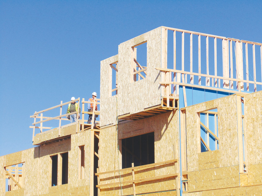 Workers build townhomes in Littleton in 2018. The rising cost of living in the city and surrounding metro area has spurred local leaders to look for new ways to ensure affordable housing.