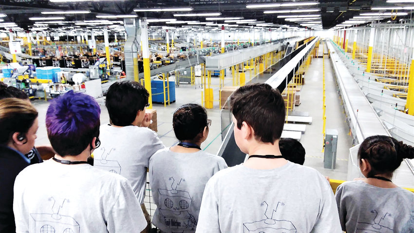 Students from Thornton's STEM Launch School look out over the Thornton Amazon warehouse April 10 from a fourth floor vantage.