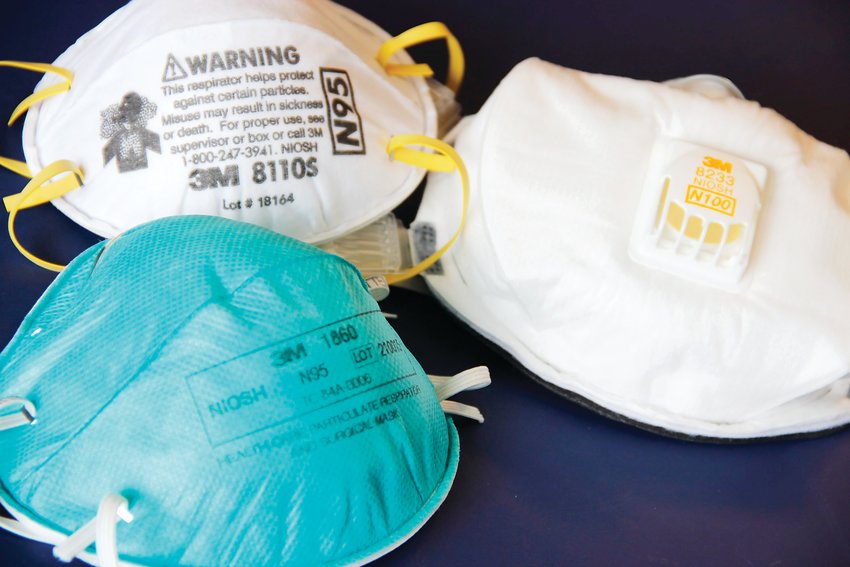 Left, two N95-type face masks, or respirators, at left. On right, a third respirator, an N100-type mask. The N95 protects against matter such as dust, aerosols and smoke, as well as biological particles, including bacteria, viruses and allergens.