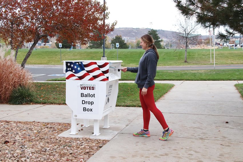 Jessica Moore of Castle Rock drops off her ballot at a walk-up location on the Douglas County Fairgrounds in town.