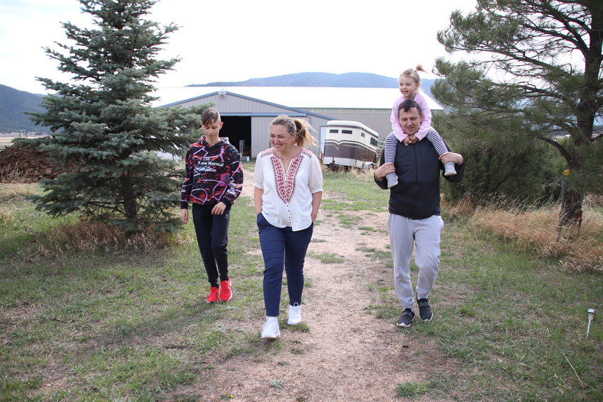 Maryna and Oleksandr Sheveria walk with two of their kids outside of the home they are staying in in Larskpur. From left, the younger Oleksandr, 14, Maryna, Oleksandr and on his shoulders, 4-year-old Taisia.