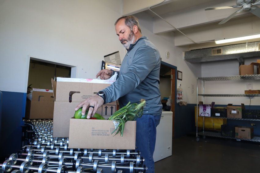 Todd McPherson, IFCS&rsquo;s director of development, prepares food boxes for a morning rush Thursday, June 2.