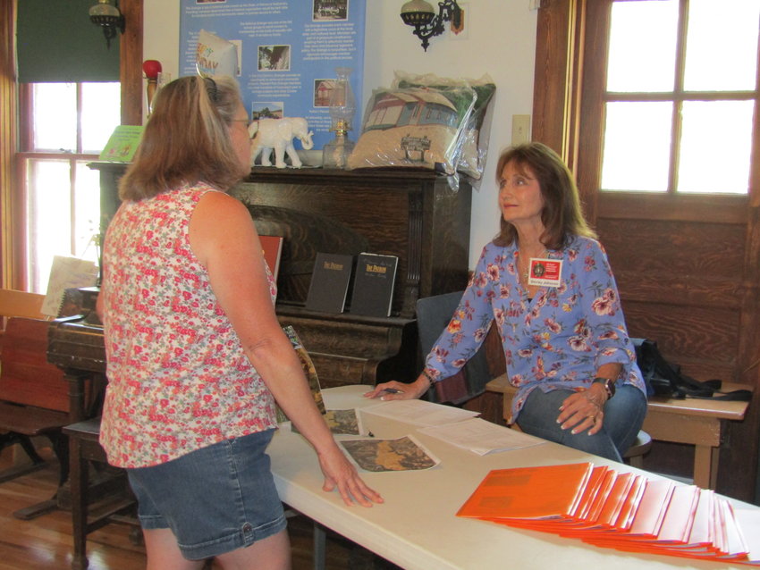 Shirley Johnson, a community ambassador in Conifer, speaks with a homeowner at an event organized by three ambassadors in June to provide wildfire-mitigation information to residents.