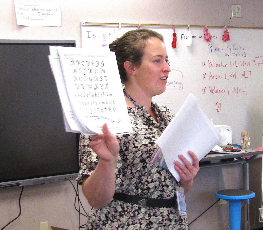 Fifth grade teacher Megan Morgenthaler explains a calligraphy exercise during colonial day.