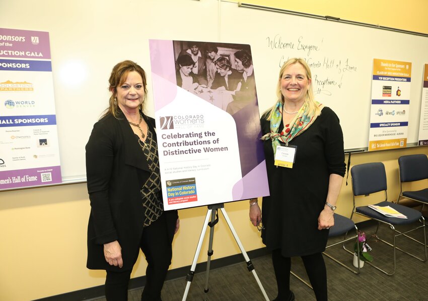 Barb Beckner, chair of Colorado Women&rsquo;s Hall of Fame, left, and Celeste Archer, executive director of National History Day in Colorado, stand with a life-size version of the &lsquo;Who Are We?&rsquo; curriculum cover.