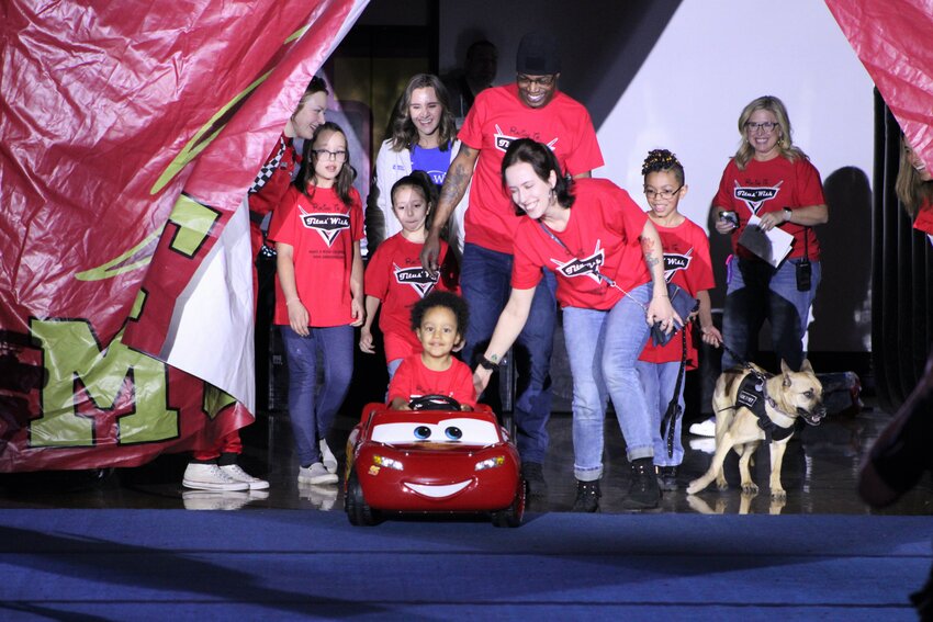 Ponderosa High School&rsquo;s featured wish kid, Titus, riding on Lightening McQueen with his family behind him.