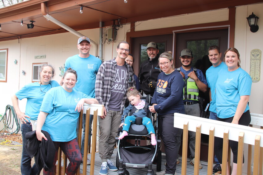 Matt, Juniper and Caroline Procik, center, surrounded by some of the volunteers from Haberer Carpentry and FirstBank who built a mobility ramp for the family through Blitz Build, a program of the nonprofit Home Builders Foundation.