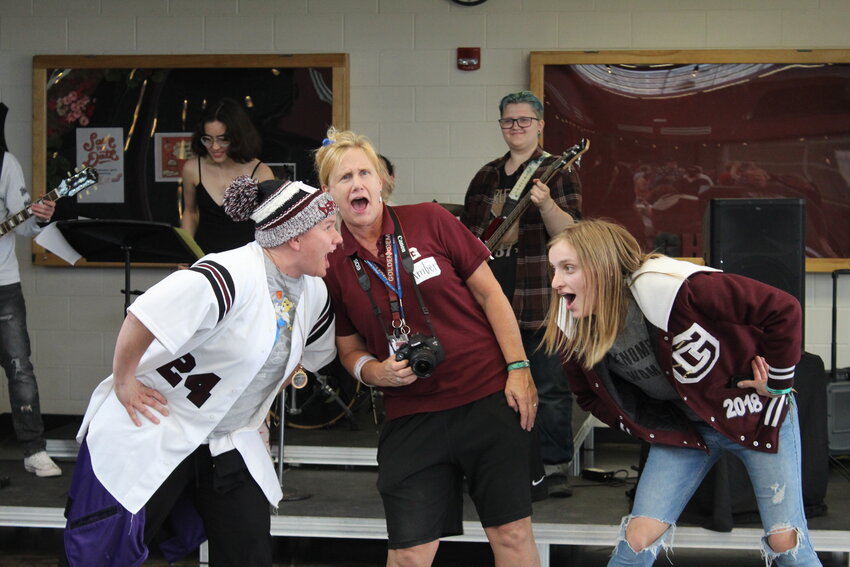 From left, Violet Cotant, Amber Hayes, and Emmy Adams perform the iconic hand jive during Golden High School's 150th anniversary celebration on June 4. Cotant and Adams graduated from GHS in 1999 and 2018, respectively, and Hayes is the current athletic secretary.