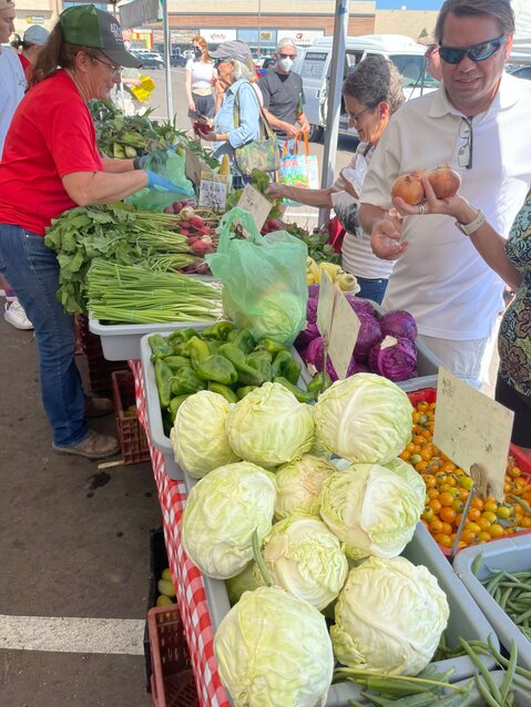 Theresa, co-owner of Metro Denver Farmers Market of Dominico Farms, sells vegetables to customers.