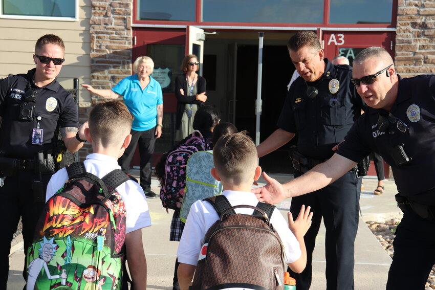 Parker Police Department officers welcoming kids into school.