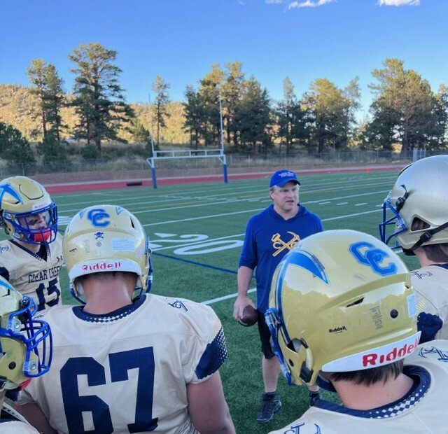 Clear Creek coach Nick Isaacson addresses his team in the huddle during the Golddiggers' home opener in week two against The Pinnacle Charter School. After Pinnacle beat Clear Creek 54-6 in 2022, the Golddiggers bounced back in a big way in 2023, winning 46-0 Thursday night, Sept. 7.