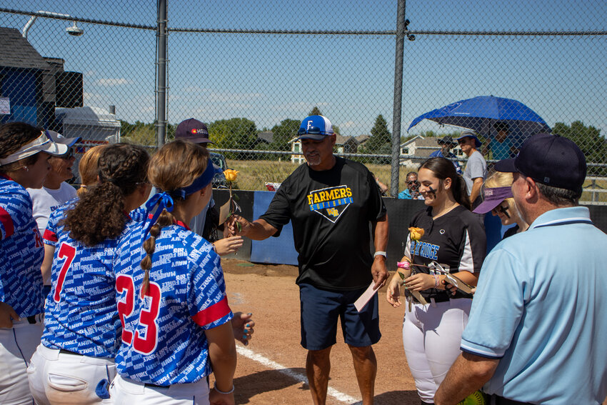 Highlands Ranch Girls softball players No. 23 Haley Raue and No. 7 Celie Page present Wheat Ridge players No. 10 Maya Dalton and Head Coach Bill Jaquish with roses ahead of game two in honor of military appreciation day.