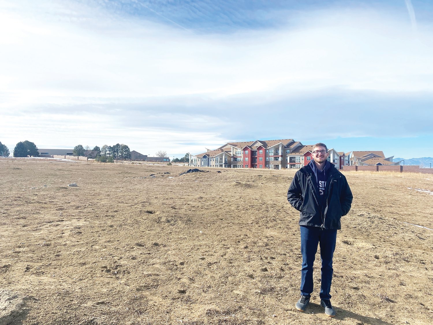 Renoff Leland poses in front of the site Flatirons Academy plans to build athletic fields, parking lots and more.