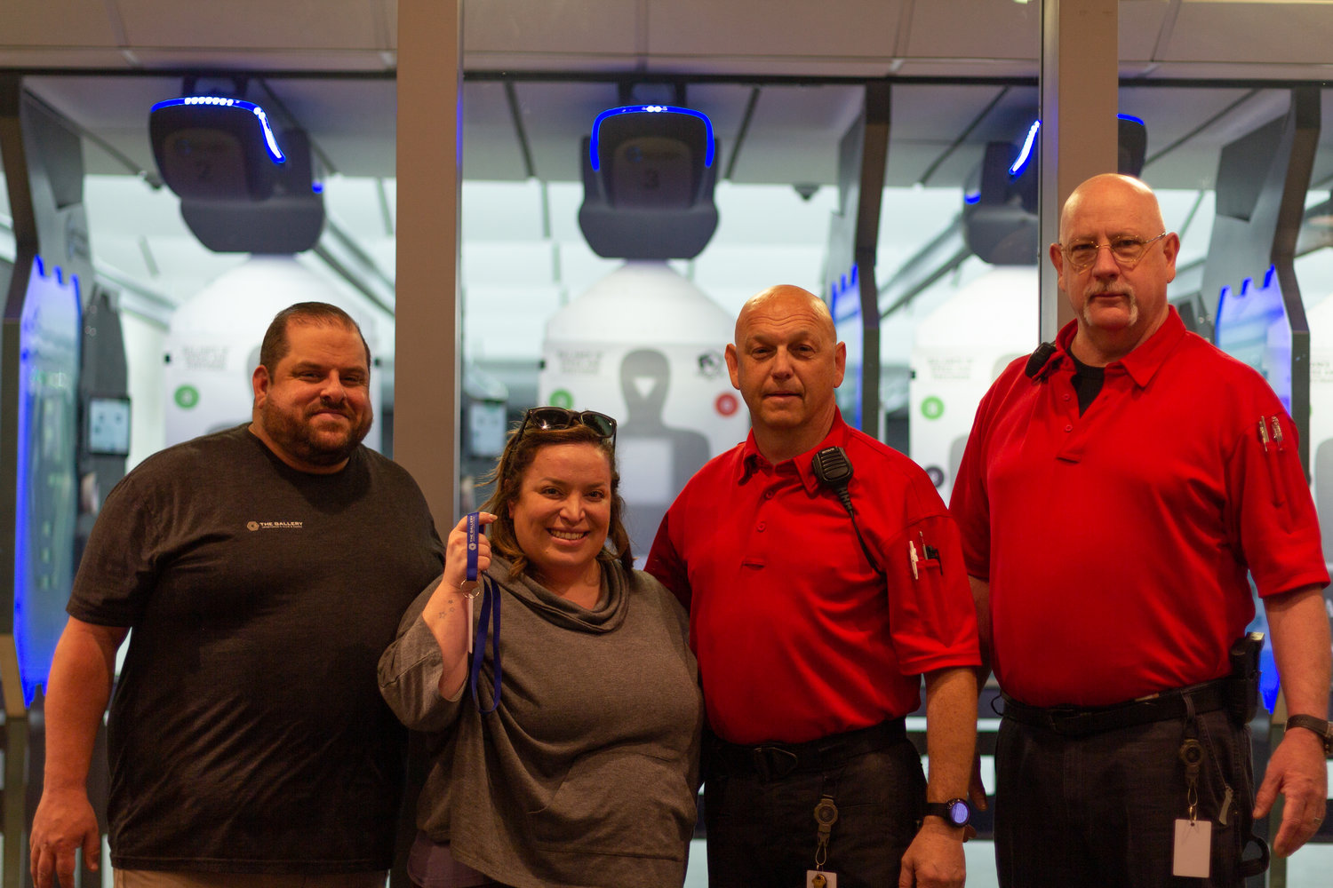 Megan Hymanson, surrounded by members of her staff, holds up an electronic card used to access shooting ranges at The Gallery, Sportsman's Club and Range in Lakewood.
