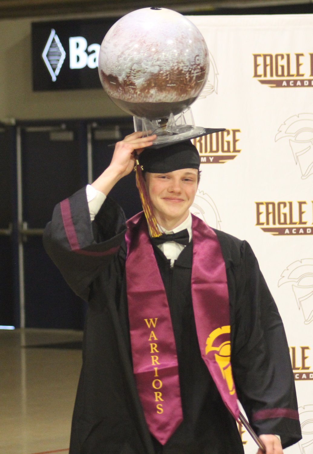 Eagle Ridge graduate Nathaniel Hershey has one hand on the diploma and one hand on his &quot;tassel&quot; at the school's commencement program at Bank of Colorado Arena in Greeley May 18.