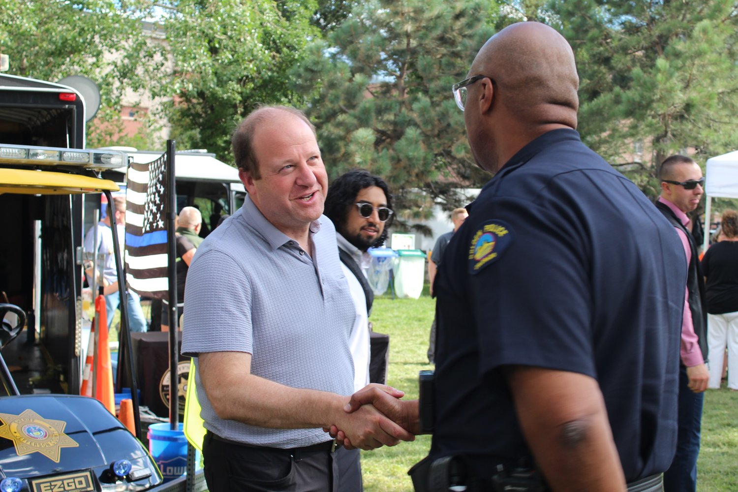 Colorado Gov. Jared Polis, left, shakes hands with Marcus Williams, Golden Police Department's commander of operations, during the city's 20th annual National Night Out event Aug. 2 at Parfet Park.