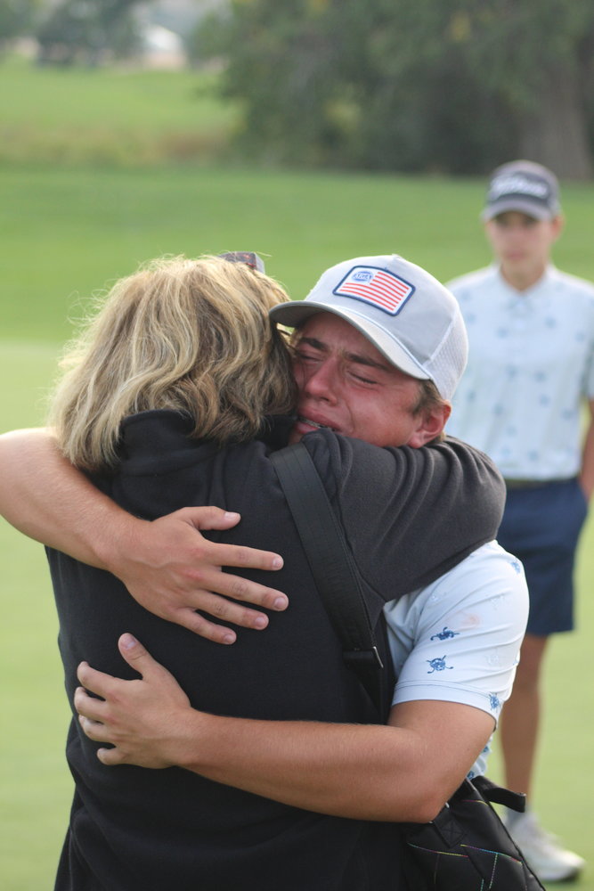 Riverdale Ridge's Bradley Weinmaster gets the winner's hug after capturing the 4A boys state golf championship in Windsor Oct. 4.
