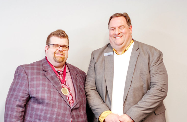 CHRISTOPHER COMBS, left, wears his award medal with Dr. Josh Black, executive director of Lee Online. Combs was named Lee Online&rsquo;s Alumnus of the Year.