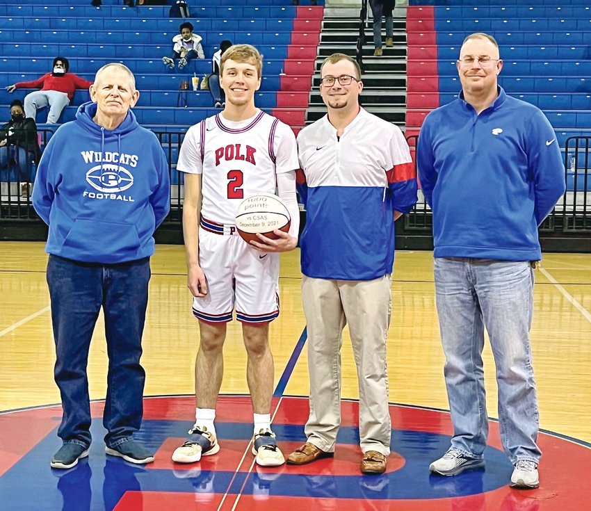POLK COUNTY WILDCAT Caleb Milen scored his 1,000th point recently. Milen was honored with a ceremony during the Wildcats' game against Tyner. From left, Polk athletics director Ron German, Caleb Milen, Polk head coach Jon Tucker, and Polk principal Adam Stone.