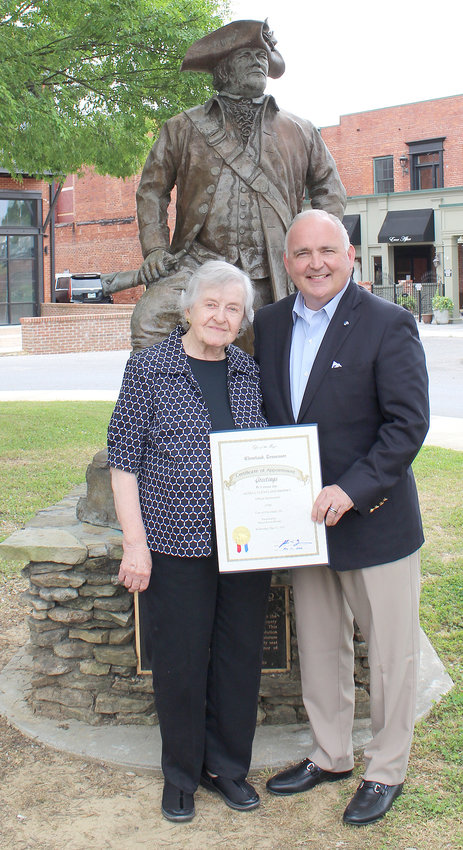 CLEVELAND Mayor Kevin Brooks and his aunt, Genell Cleveland, stand in front of a statue of Revolutionary War hero Col. Benjamin Cleveland while the mayor presents his aunt a document recognizing her as an official ambassador for the city. Brooks' aunt, who resides in Dallas, Georgia, is a direct descendent of Jacob Cleveland, the brother of Col. Cleveland, for whom this city is named.