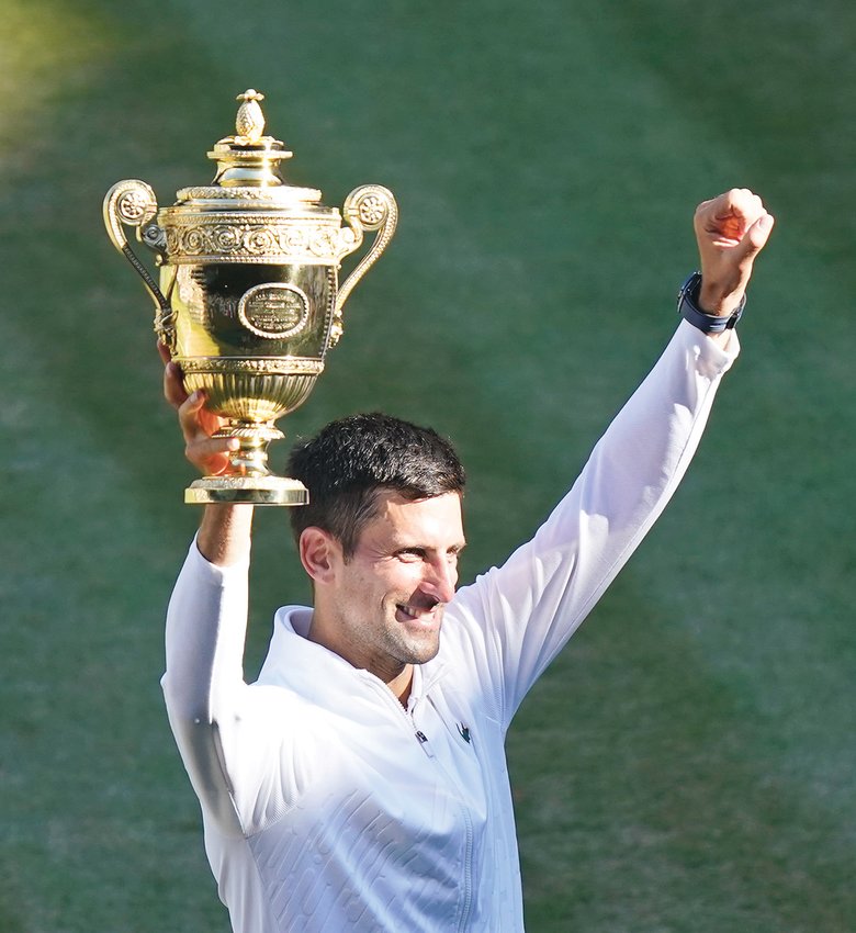 SERBIA'S NOVAK DJOKOVIC holds up the winners trophy after beating Australia's Nick Kyrgios to win his seventh Wimbledon Singles Championship, in London, Sunday.
