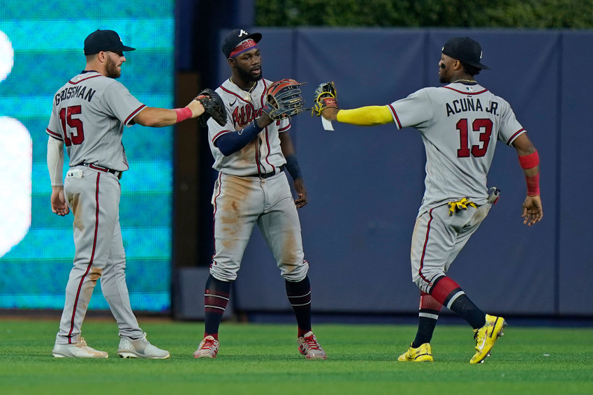 ATLANTA BRAVES left fielder Robbie Grossman (15) center fielder Michael Harris II (23) and right fielder Ronald Acuna Jr. (13) celebrate after the Braves beat the Miami Marlins 5-2 during the first game of a baseball doubleheader, Saturday, in Miami. The Braves completed the sweep with a 6-2 win in the nightcap.
