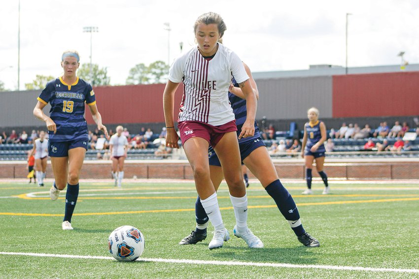 LEE WOMEN'S soccer's Julianna Lopes battles against a pair of Cedarville defenders during the Lady Flames Opening Kickoff Weekend Saturday. Lopes scored the Lady Flames' only goal on the way to a 1-1 draw.