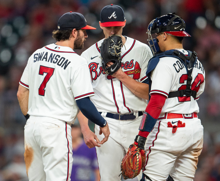 ATLANTA BRAVES SS Dansby Swanson left, and catcher William Contreras left, visit mound to speak with starting pitcher Kyle Wright, center, during the fourth inning of Wednesday's game against the Colorado Rockies, in Atlanta. Wright secured his Major League leading 17th win of the season.