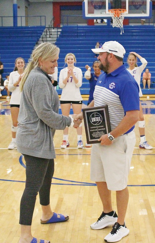 CLEVELAND HIGH AD Al Morris Jr., right, congratulates head volleyball coach Amy McGowan on having reached the 100-win plateau earlier this season before Thursday evening's District 5-AAA action with Ooltewah, at Raider Arena.