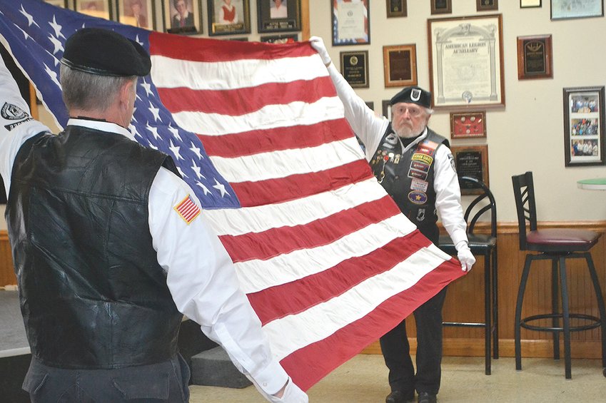 ROLLING THUNDER members Bryan Trentham (left) and Rob Rolli perform the ceremonial folding of the flag at the POW/MIA remembrance event at the American Legion Post 81 on Saturday.