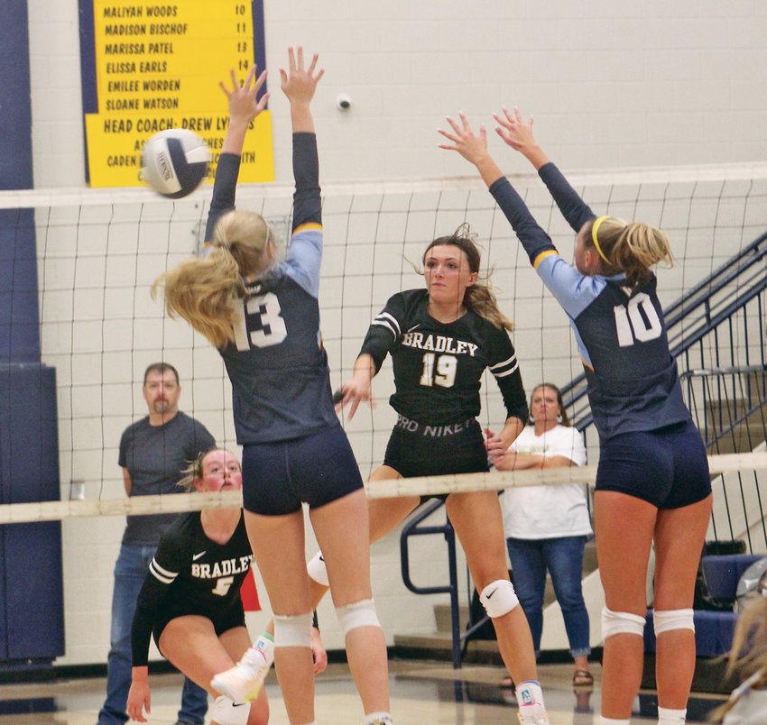 BRADLEY CENTRAL'S Trinity Reagan (19) sends a shot past Walker Valley's Chaislyn Witt (13) and Bella Beard (10) during Thursday night's district match. The Bearettes won the rivalry match in five sets.