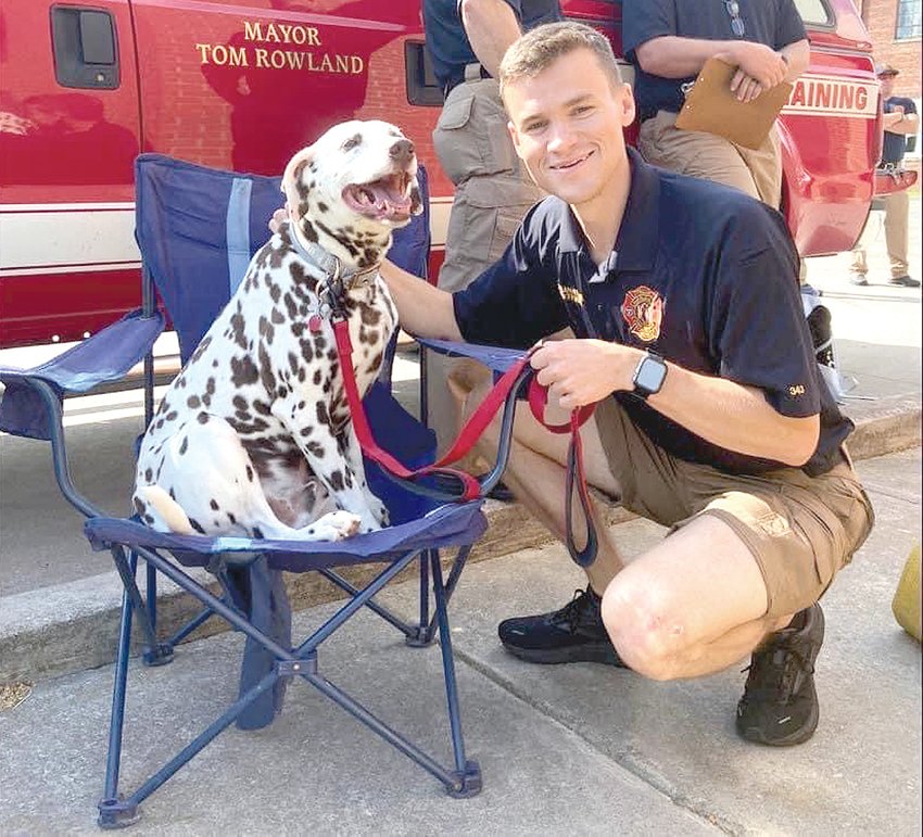 Logan Helton, right, poses with dalmatian Higbee at the Cleveland Fire Department.
