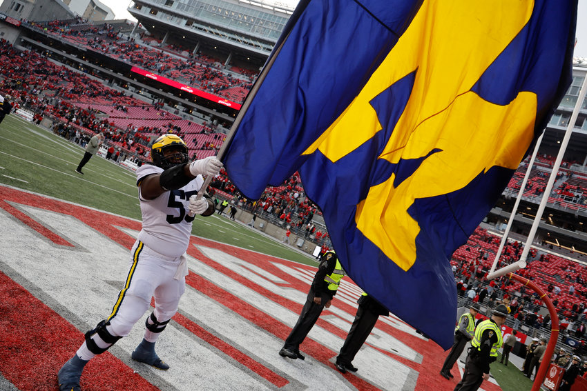 Michigan offensive lineman Trente Jones waves their flag to celebrate their win over Ohio State Saturday in Columbus, Ohio.