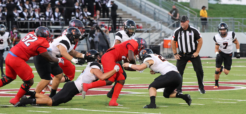 Christian Hillman (21) makes a tackle along with Andrew Parkhurst (27).