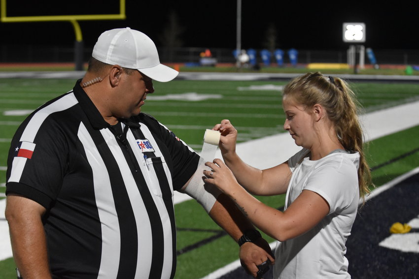 Athletic trainer Skylar Tinsley provides quick first-aid to a referee.