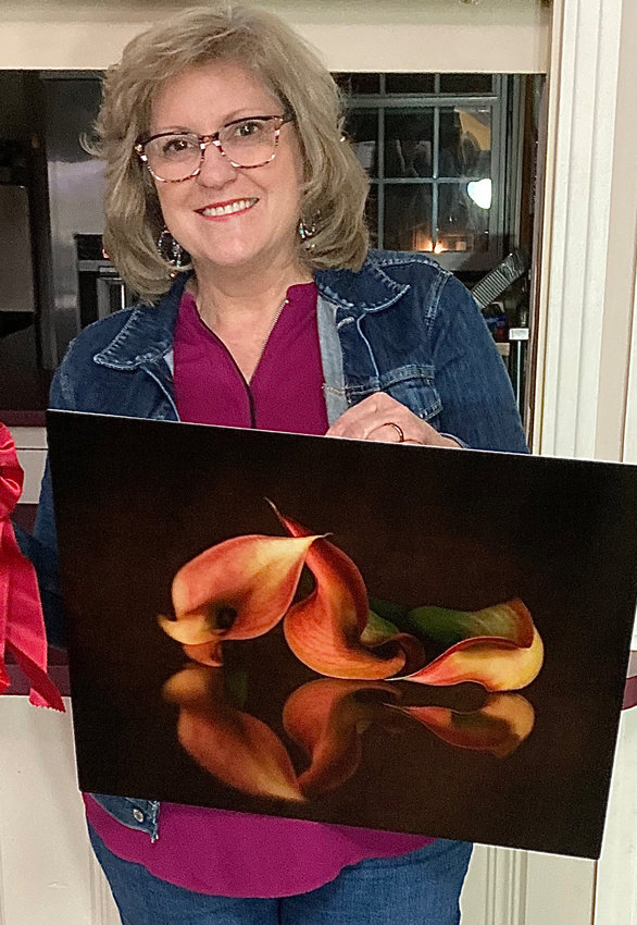Photographer Carmen Davailus, shows her second-place entry, a photograph on metal, “Grace and Strength.”